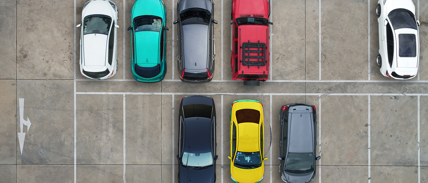 A busy parking lot showcasing multiple cars parked in organized spaces.
