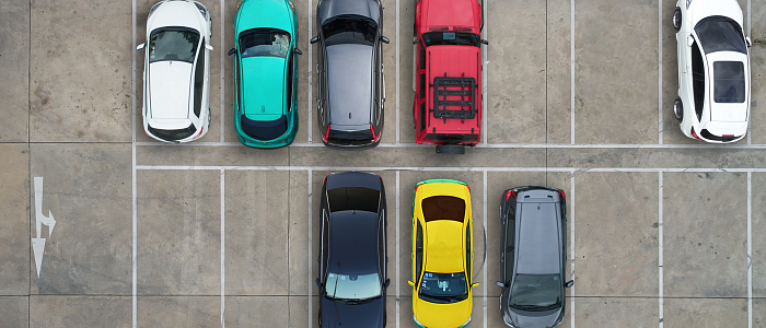 A busy parking lot showcasing multiple cars parked in organized spaces.